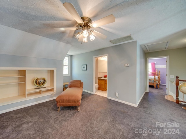 sitting room with ceiling fan, a textured ceiling, lofted ceiling, and dark colored carpet