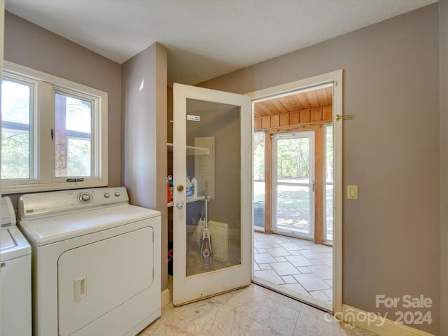 clothes washing area with washer and clothes dryer and a healthy amount of sunlight