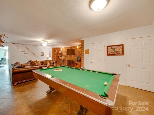 playroom with brick wall, pool table, a fireplace, and tile patterned flooring