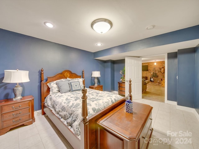 tiled bedroom with connected bathroom and brick wall