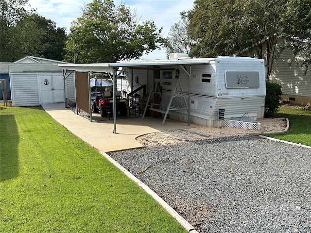 back of house with a yard, a shed, a patio, and a carport