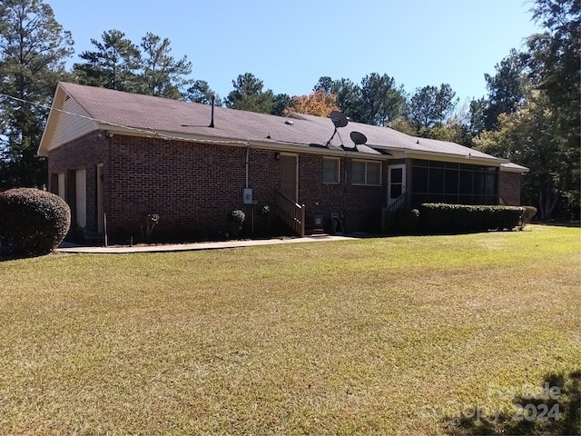 back of property with a sunroom and a lawn