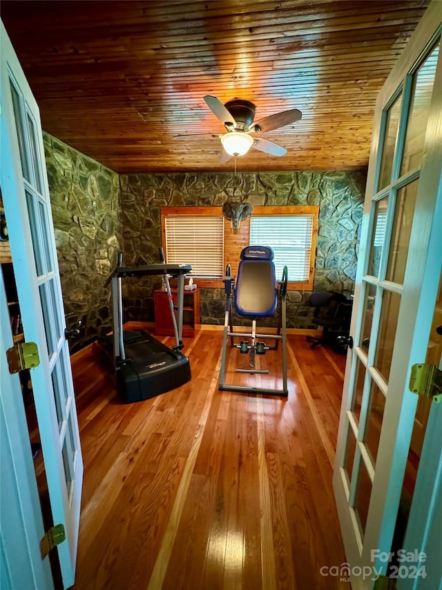 workout room with hardwood / wood-style flooring, ceiling fan, wooden ceiling, and french doors