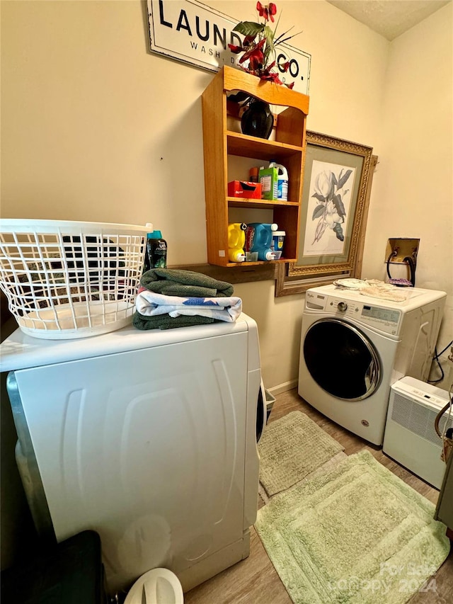 clothes washing area with hardwood / wood-style flooring and separate washer and dryer