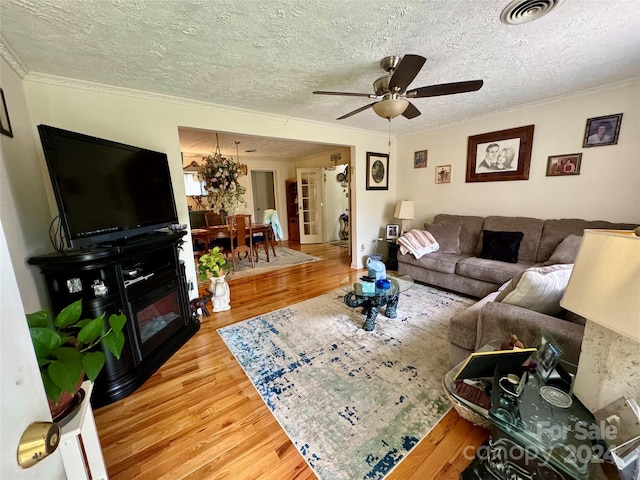 living room featuring crown molding, a textured ceiling, and hardwood / wood-style flooring