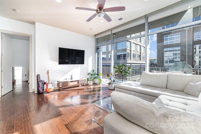 living room with ceiling fan, wood-type flooring, and a wall of windows