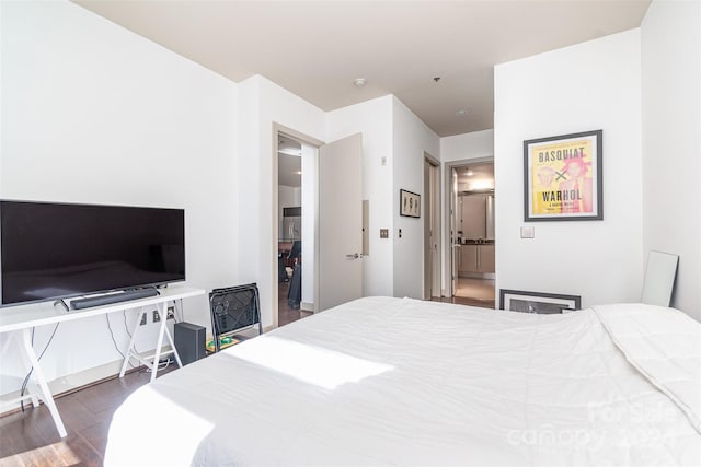 bedroom with dark hardwood / wood-style floors and ensuite bathroom