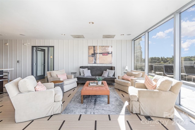 living room with expansive windows, a healthy amount of sunlight, and light wood-type flooring