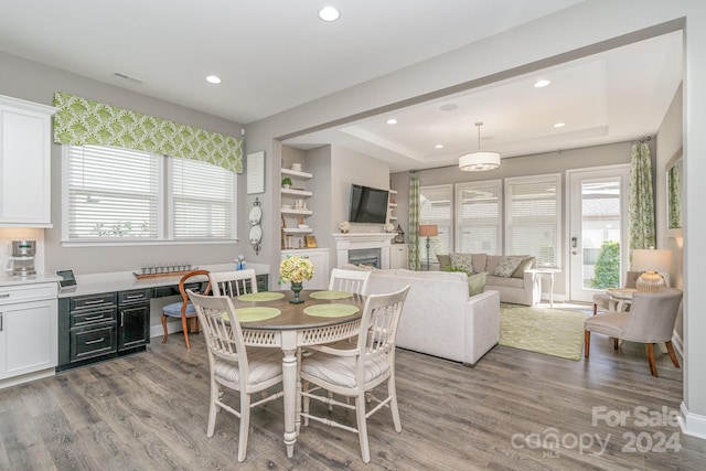 dining room featuring light hardwood / wood-style flooring and a tray ceiling