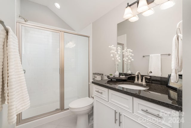 bathroom with tile patterned floors, toilet, vaulted ceiling, vanity, and a shower with shower door