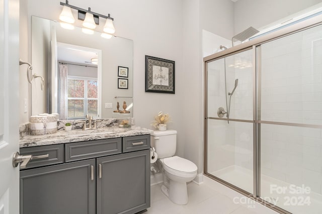 bathroom featuring walk in shower, tile patterned flooring, vanity, and toilet