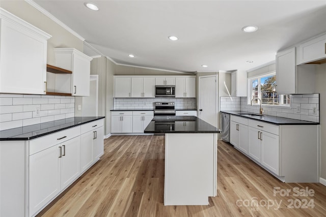 kitchen featuring white cabinetry, crown molding, stainless steel appliances, and light hardwood / wood-style flooring