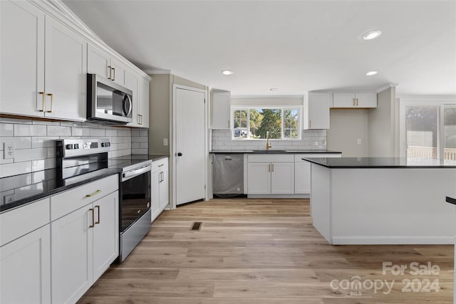 kitchen featuring white cabinetry, light hardwood / wood-style flooring, appliances with stainless steel finishes, and sink