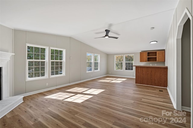 unfurnished living room with lofted ceiling, wood-type flooring, and ceiling fan