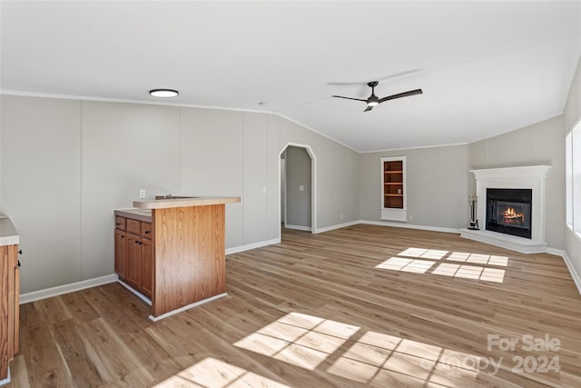 unfurnished living room featuring light hardwood / wood-style floors, ornamental molding, ceiling fan, and vaulted ceiling