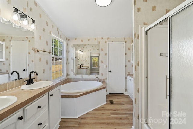 bathroom featuring vanity, wood-type flooring, and plus walk in shower