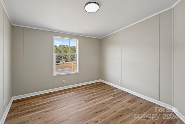 spare room with light hardwood / wood-style flooring and crown molding