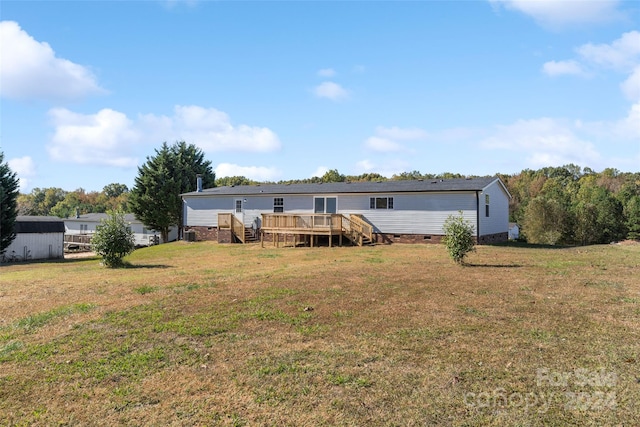 rear view of property with a wooden deck and a yard