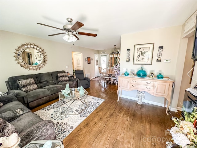 living room featuring ceiling fan and dark hardwood / wood-style flooring