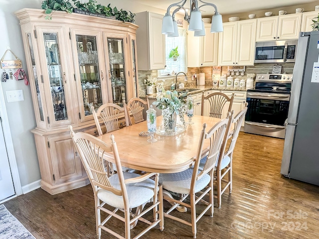 dining room featuring a notable chandelier, hardwood / wood-style flooring, and sink