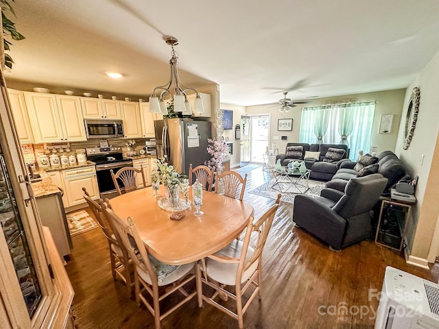 dining room featuring dark hardwood / wood-style flooring and ceiling fan with notable chandelier