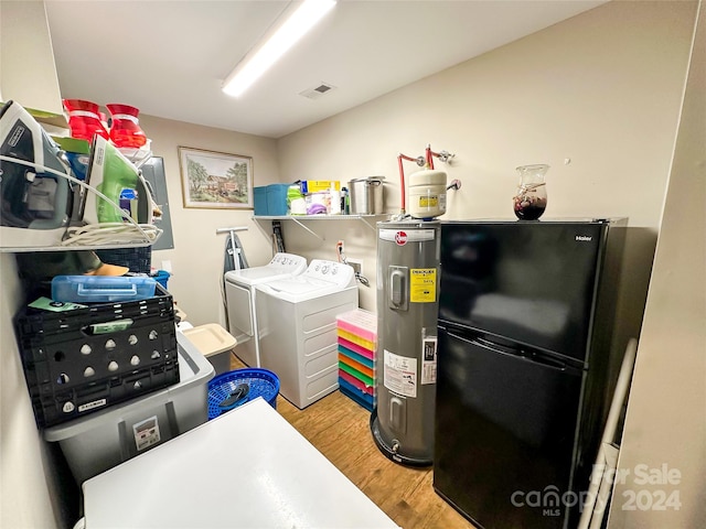 washroom with light hardwood / wood-style floors, electric water heater, and separate washer and dryer