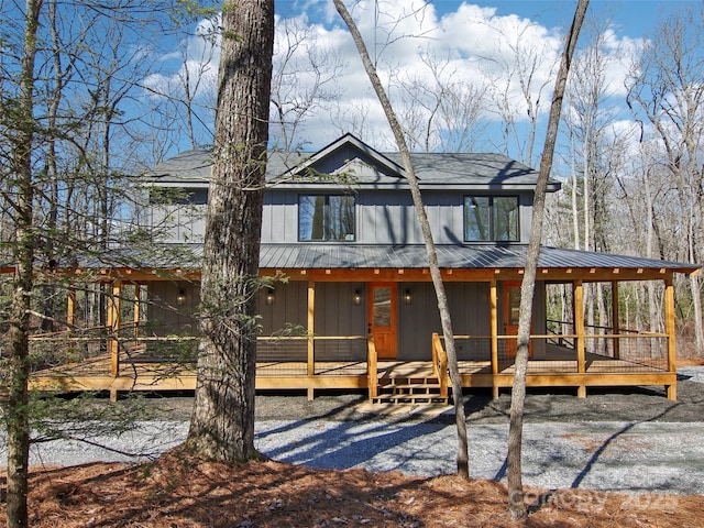 view of front of property featuring board and batten siding, metal roof, and a deck