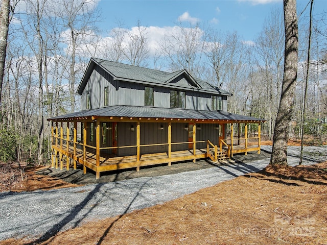 view of front of property featuring a standing seam roof, metal roof, roof with shingles, and a sunroom