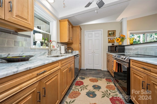 kitchen featuring light stone counters, tasteful backsplash, appliances with stainless steel finishes, and sink