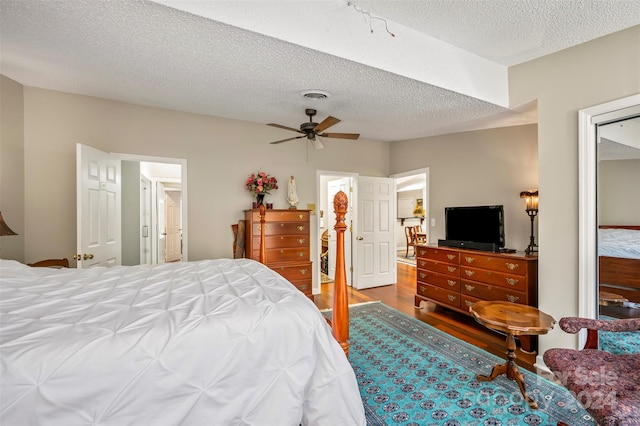 bedroom featuring hardwood / wood-style floors, a textured ceiling, and ceiling fan