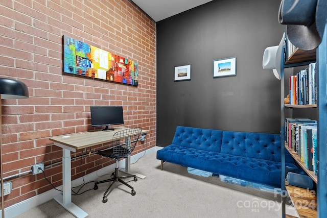 office with carpet floors and brick wall