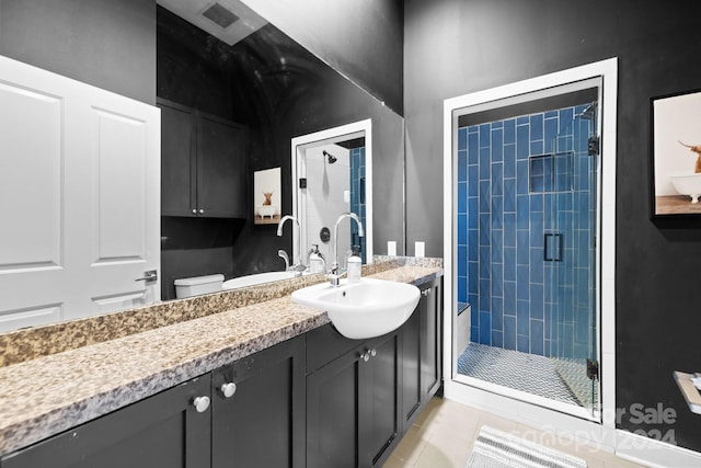 bathroom with vanity, tile patterned floors, toilet, and walk in shower