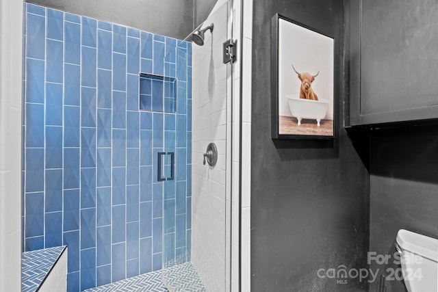 bathroom with toilet and an enclosed shower