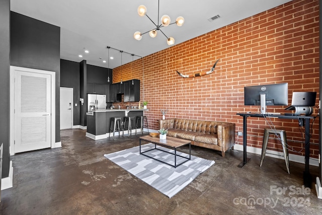 living room with brick wall, a high ceiling, and an inviting chandelier