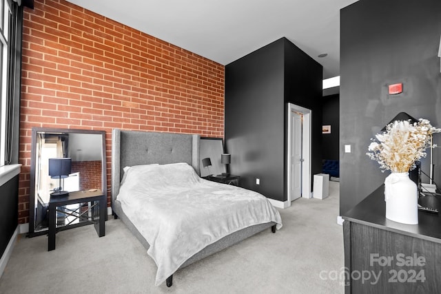 bedroom featuring brick wall and light colored carpet