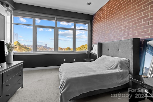 carpeted bedroom with brick wall