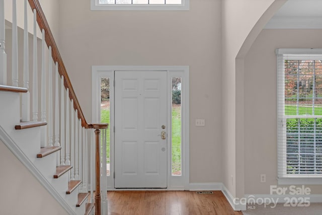 entrance foyer with light hardwood / wood-style flooring and crown molding