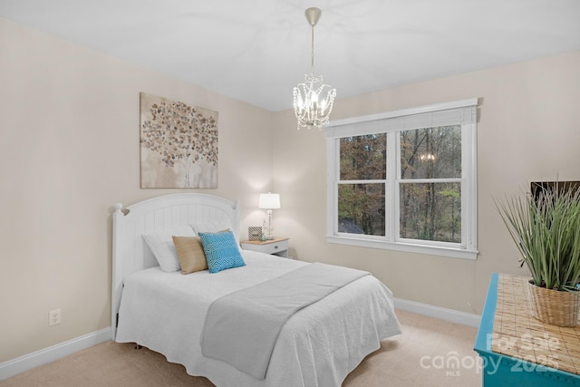 bedroom featuring light colored carpet and a notable chandelier