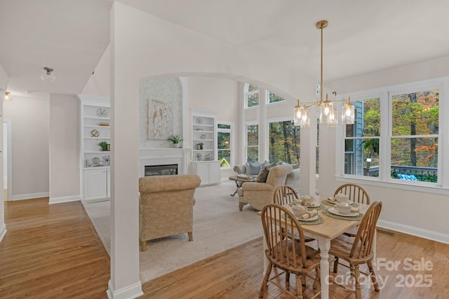 dining room with plenty of natural light, light hardwood / wood-style floors, and a notable chandelier