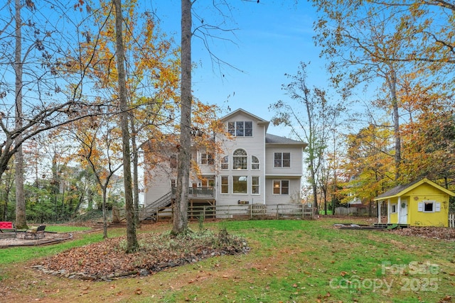 rear view of property with an outdoor structure and a yard