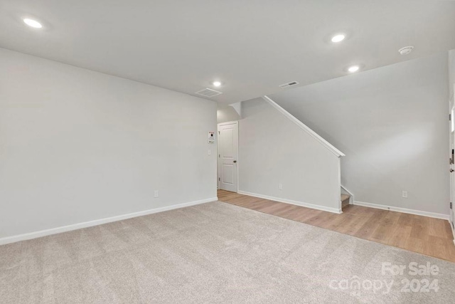 unfurnished living room with light hardwood / wood-style floors and lofted ceiling