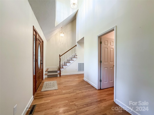 foyer featuring vaulted ceiling and light hardwood / wood-style flooring