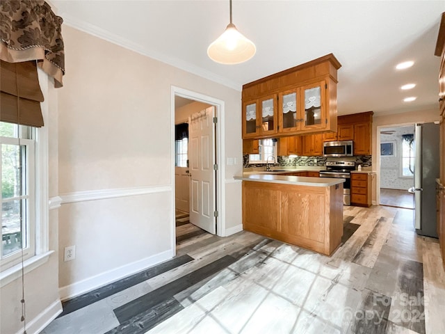 kitchen featuring light hardwood / wood-style flooring, hanging light fixtures, kitchen peninsula, sink, and appliances with stainless steel finishes