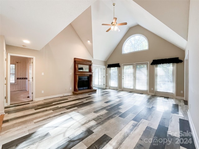 unfurnished living room featuring hardwood / wood-style flooring, high vaulted ceiling, and ceiling fan