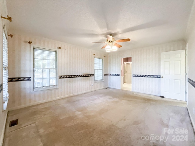 unfurnished room featuring light carpet, a textured ceiling, and ceiling fan