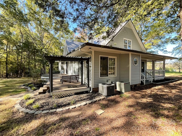 exterior space featuring a deck, central AC unit, and a pergola