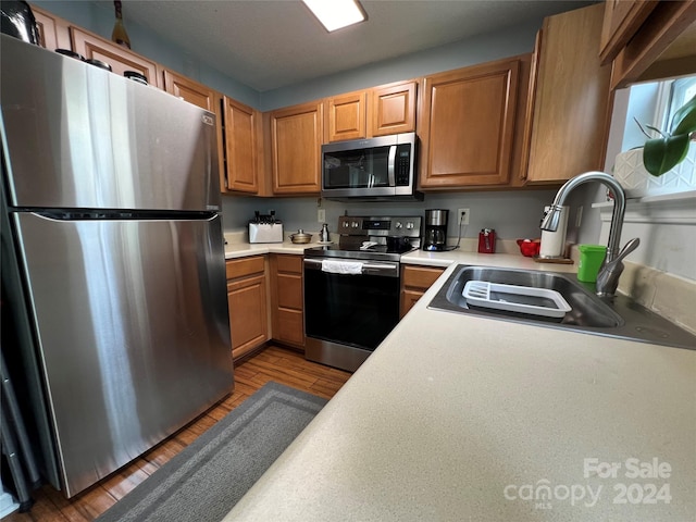 kitchen with light hardwood / wood-style flooring, stainless steel appliances, and sink