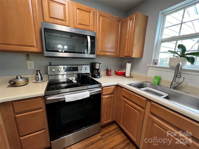 kitchen featuring appliances with stainless steel finishes, sink, and light wood-type flooring