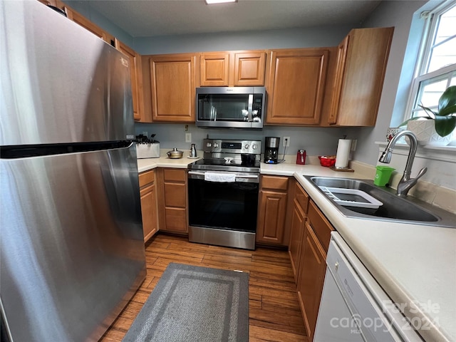 kitchen with sink, appliances with stainless steel finishes, and light hardwood / wood-style floors