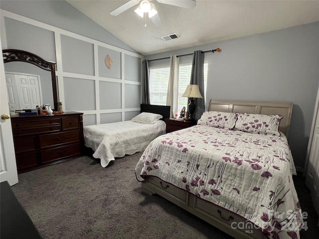 bedroom with ceiling fan, a textured ceiling, vaulted ceiling, and dark carpet